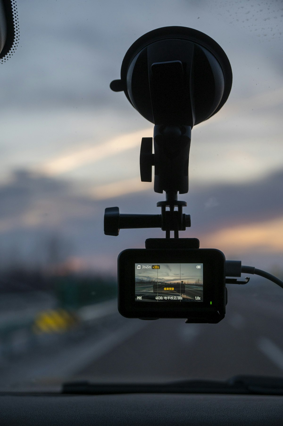 A dash cam mounted on a car windshield